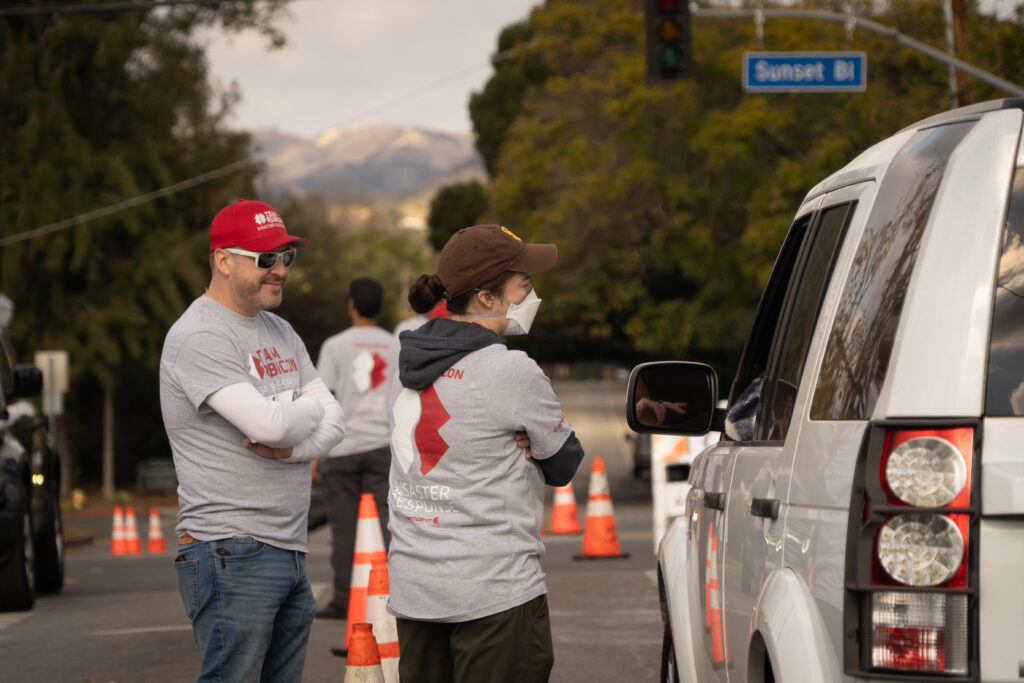 volunteers greet homeowners looking to return home and advise them about risks of fire debris removal