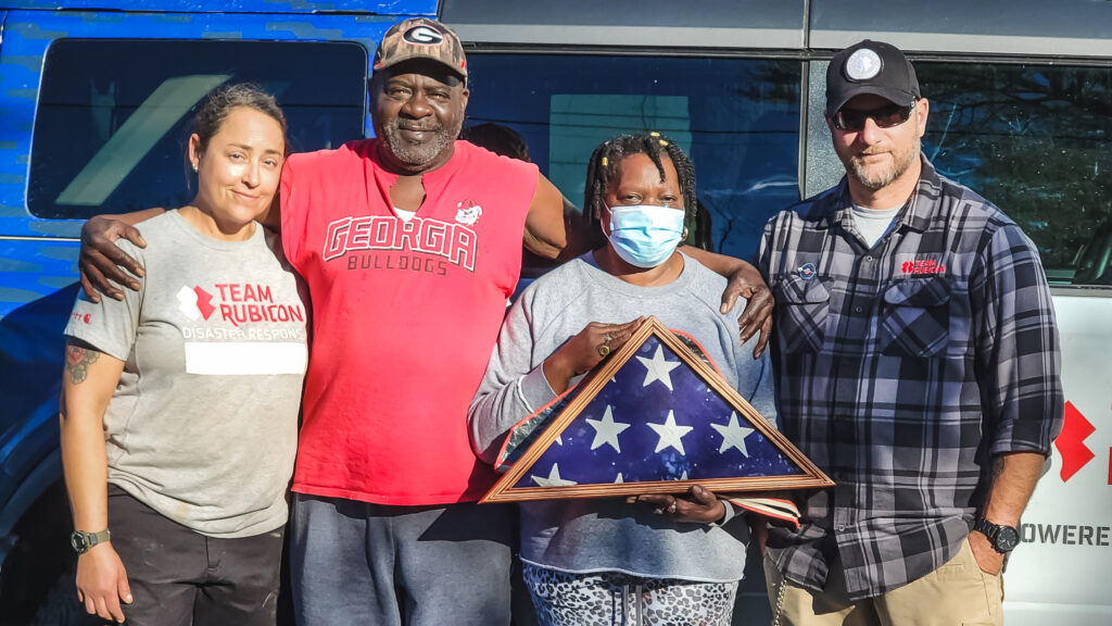 volunteers and homeowner with lost flag